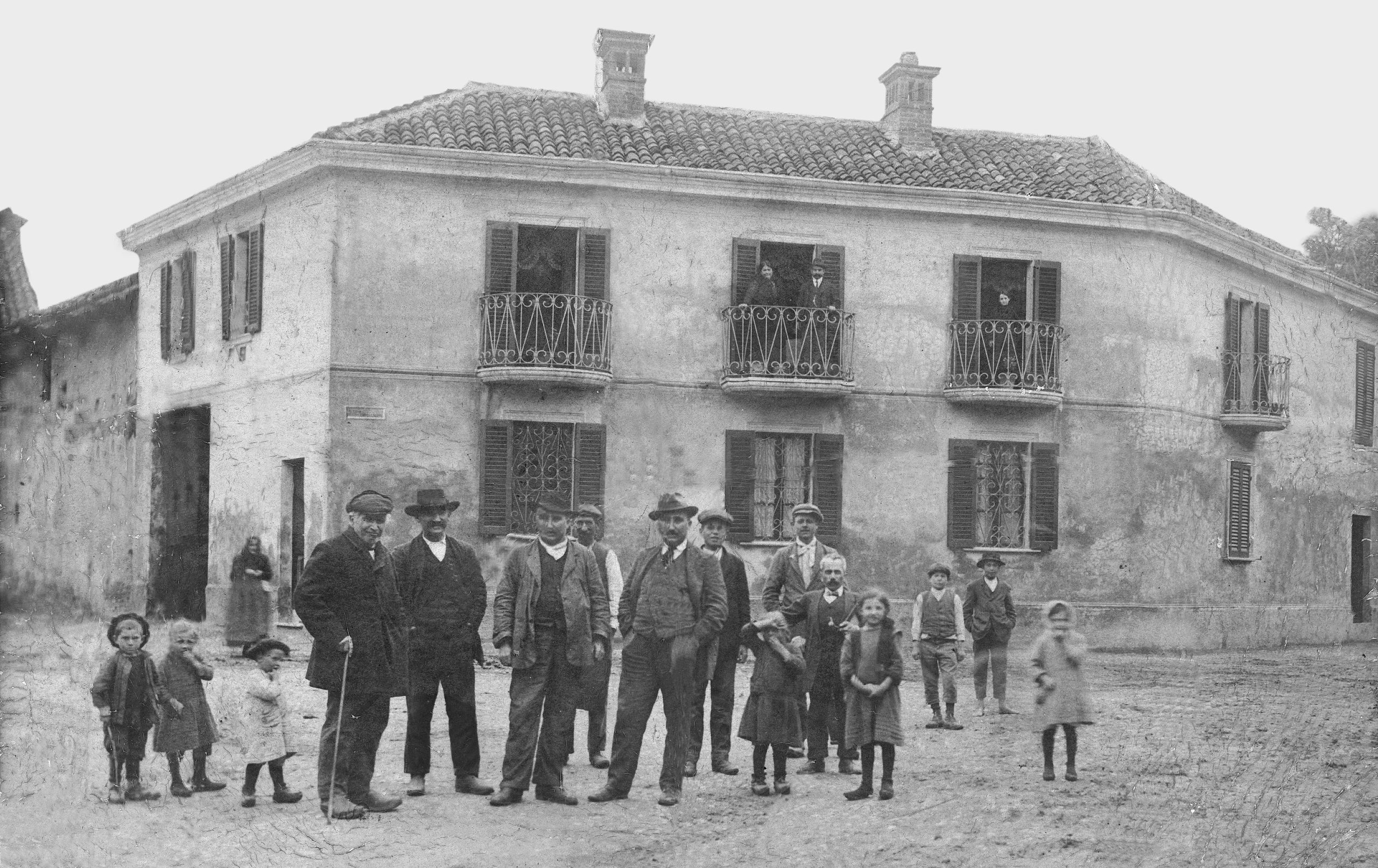 Gruppo di abitanti di Alagna in posa all’angolo tra piazza Castello e corso Vittorio Veneto